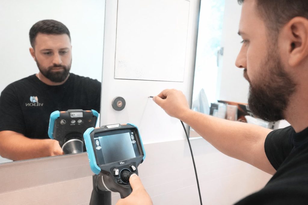 Mann mit Endeskopkamera bei der Leckortung im Badezimmer